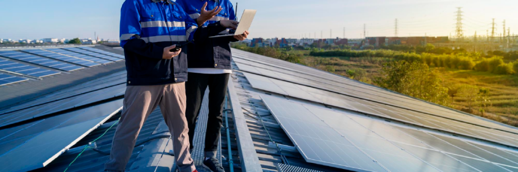 วิศวกรใช้แท็บเล็ตตรวจสอบระบบ Solar Rooftop บนหลังคาโรงงาน